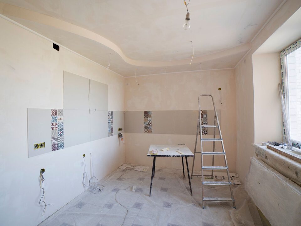 A room under renovation with tools and a ladder